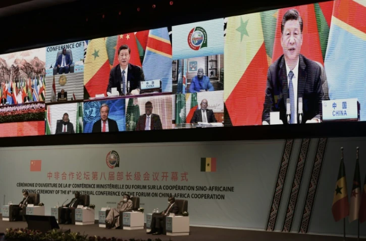 Le président chinois Xi Jinping (à l'écran) fait un discours devant le forum de coopération sino-africaine qui se tient à Dakar, le 29 novembre 2021