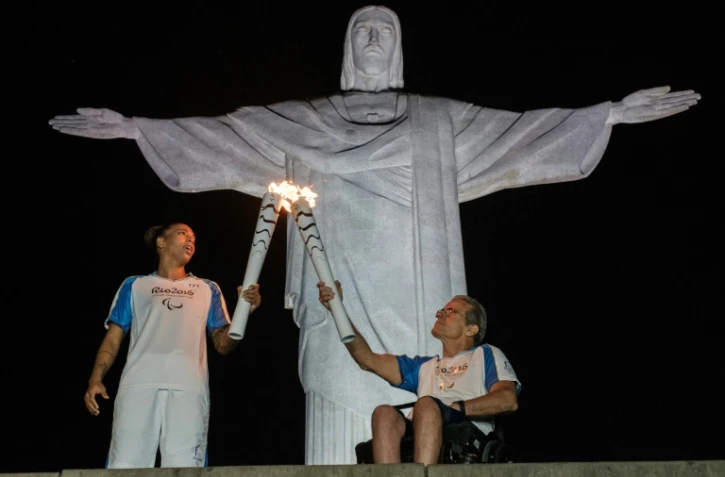 Passage de relais de la torche olympique entre Thomas Magalhaes (D) et la judoka brésilienne Rafaela Silva, pour les Jeux Paralympiques le 6 septembre 2016 à Rio 
