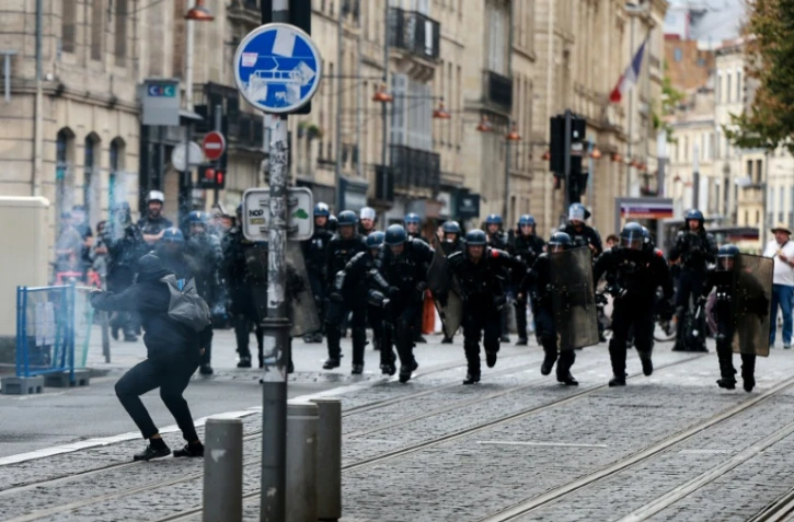 Des gendarmes mobiles chargent un manifestant pointant un mortier d'artifices vers eux pendant une manifestation lycéenne à Bordeaux, le 1er octobre 2026