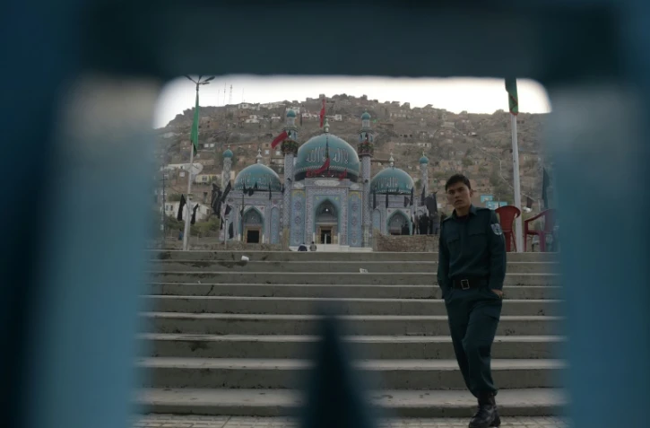 Un policier afghan surveille l'entrée principale de la mosquée chiite de Karte Sakhi après une attaque, le 12 octobre 2016 à Kaboul