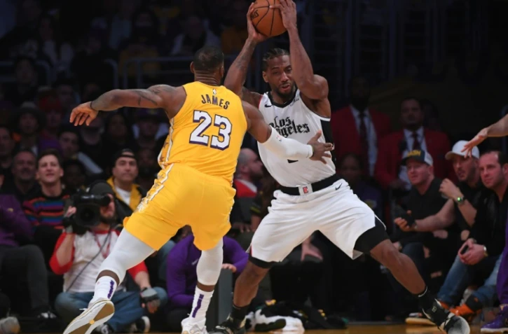 Kawhi Leonard des Los Angeles Clippers (d) à la lutte avec LeBron James des Los Angeles Lakers, en NBA au Staples Center, le 25 décembre 2019