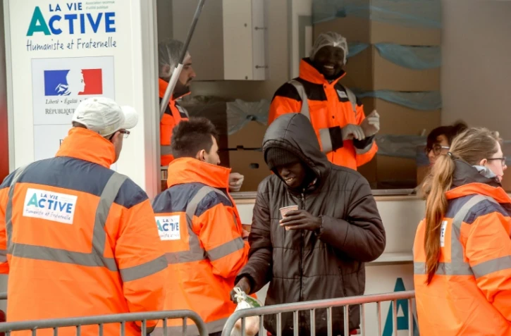 Des bénévoles de l'association La Vie Active distribuent des repas à des migrants à Calais, le 6 mars 2018