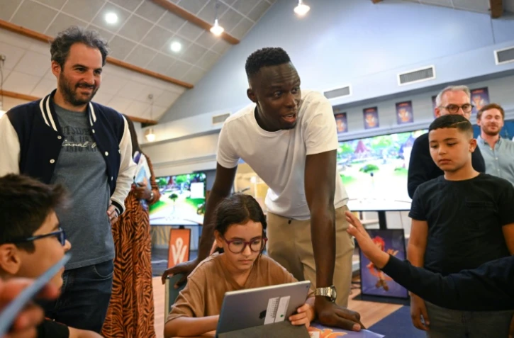 Le gardien de but français de Chelsea, Edouard Mendy (D) rencontre des élèves de l'école primaire Diderot tout en apportant son soutien financier à PowerZ, un jeu vidéo éducatif gratuit, à Drancy, dans la banlieue nord de Paris, le 11 juin 2022