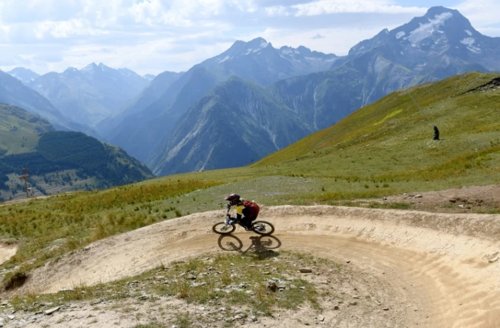 Un cycliste pratique le VTT Alpin, VTT de descente en montagne, le 31 juillet 2017 sur une piste des Deux-Alpes, dans l'IsĂšre