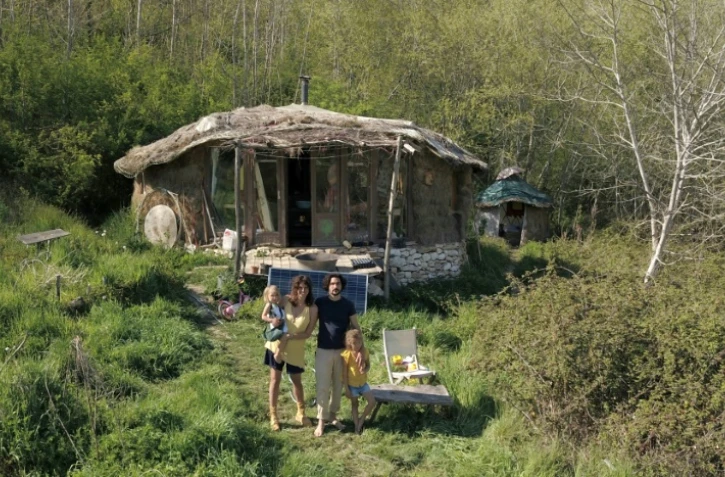 Jonathan Attias, 34 ans, Caroline Perez, 35 ans, et leurs deux filles devant leur cabane à Chasteaux (Corrèze), le 23 avril 2021