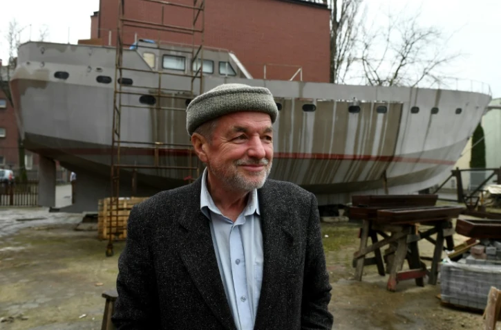 Le capitaine Waldemar Rzeznicki devant la coque d'un voilier construit par des SDF à Varsovie le 27 mars 2017