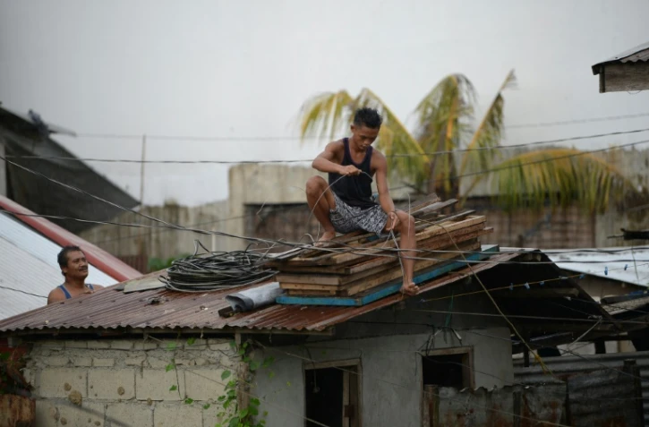 Des habitants protègent leur toit à l'approche d'un super typhon à Tuguegarao aux Philippines le 14 septembre 2018