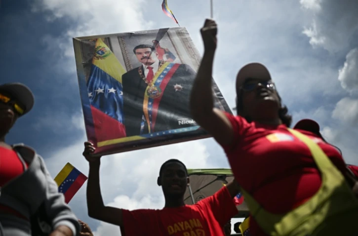 Un homme tient un portrait du président vénézuélien Nicolas Maduro, le 23 septembre 2025 à Caracas