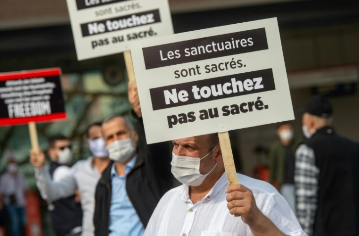 Des manifestants turcs brandissent des pancartes écrites en français contre le président Emmanuel Macron, le 27 octobre 2020 à Istanbul
