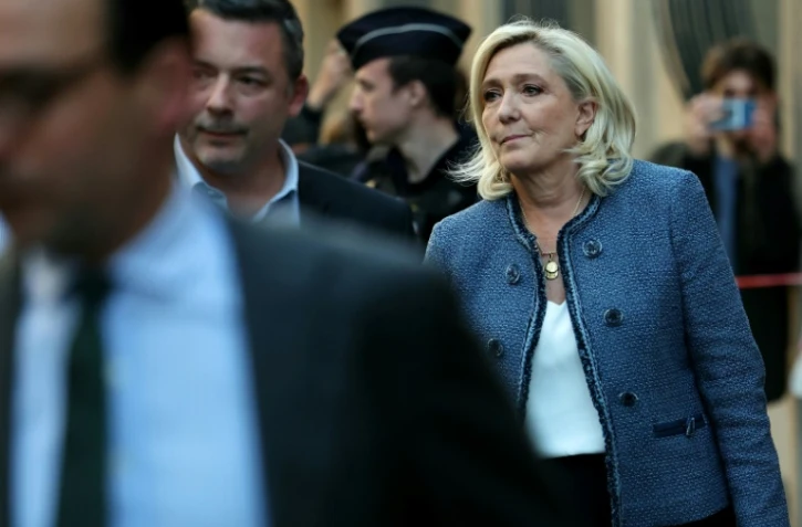Marine Le Pen (d.), présidente du groupe parlementaire du Rassemblement national (RN), quitte le siège du parti, à Paris, le 31 mars 2025