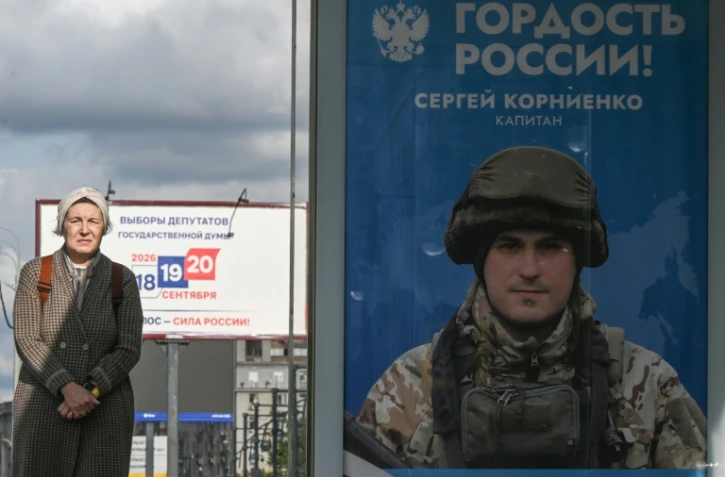 Une passante près d'une affiche faisant la promotion de l'armée russe en Ukraine sur laquelle on peut lire "Fierté de la Russie", à Moscou le 15 septembre 2026