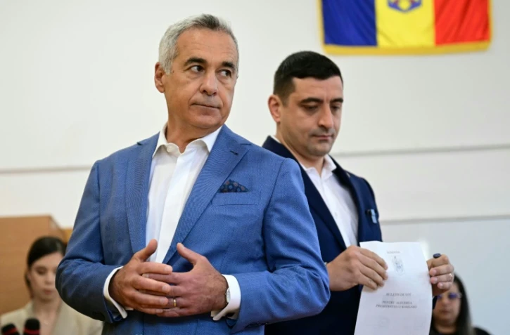 Le chef du parti nationaliste AUR et candidat à la présidentielle roumaine George Simion vote aux côtés de Calin Georgescu, exclu de la course, le 4 mai 2025 à Bucarest