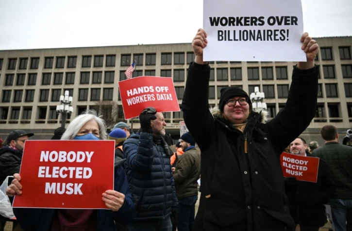  Des manifestants brandissent des pancartes lors d'une protestation contre le président américain Donald Trump et le Doge, la commission confiée à Elon Musk, devant le ministère américain du Travail près du Capitole à Washington le 5 février 2025  