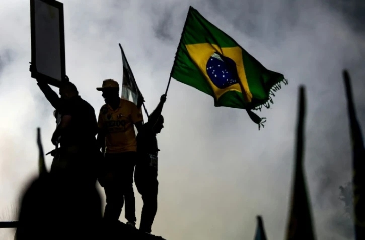 Un partisan du sénateur brésilien de droite et candidat à la présidence, Flavio Bolsonaro, agite un drapeau national lors d'un meeting de campagne à Rio de Janeiro, le 3 octobre 2026