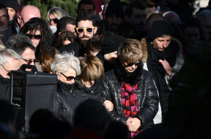 Des personnes se recueillent devant la mairie de Saint-Féliu-d'Avall le 17 décembre 2017