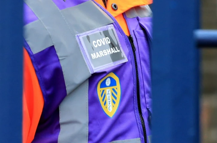 Un Covid Marshall chargé de surveiller le statut sanitaire des supporters à leur arrivée au stade de Leeds avant un match de Premier League contre Arsenal le 18 décembre 2021