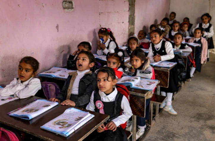 Des élèves suivent un cours dans une salle de classe d'une école située dans le centre de l'Irak, le 10 mars 2024