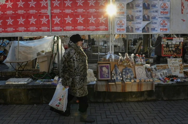 Une femme passe devant des affiches électorales à Chisinau le 13 février 2019