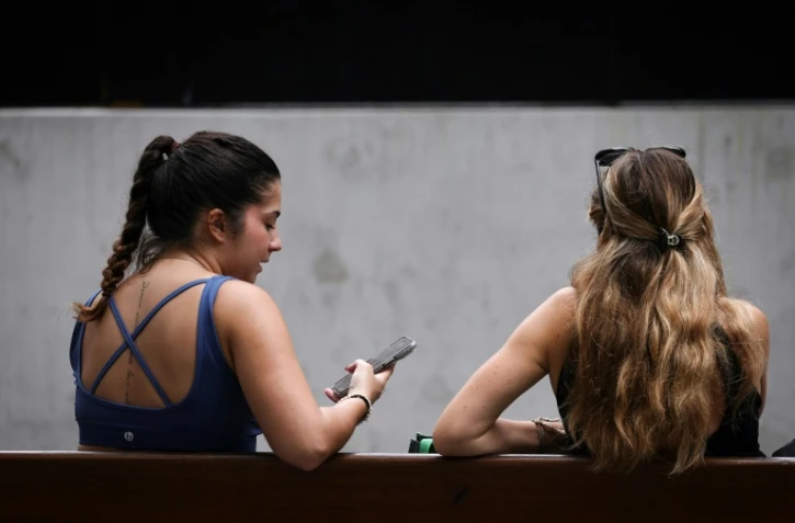 Deux jeunes filles sur leur téléphone à Sydney, le 7 novembre 2024