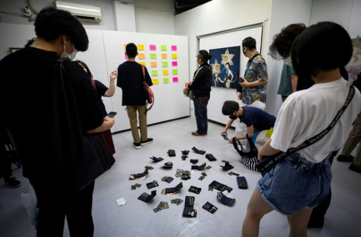 Des visiteurs regardent des oeuvres exposées dans la galerie d'art Same où le vol des oeuvres est permis, le 9 juillet 2020 à Tokyo