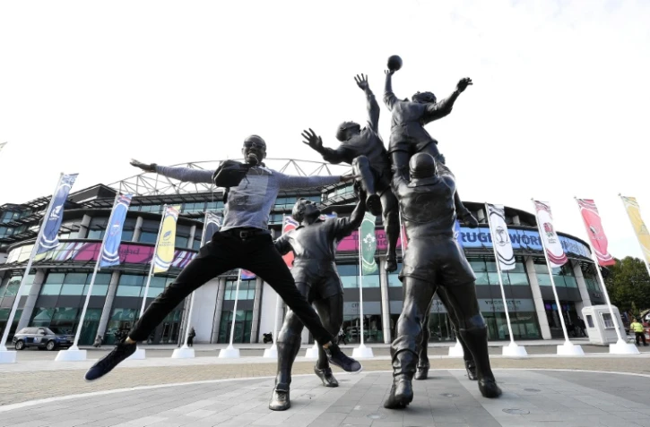 Un homme devant les statues de joueurs de rugby devant le stade Twickenham le 17 septembre 2015 à Londres 