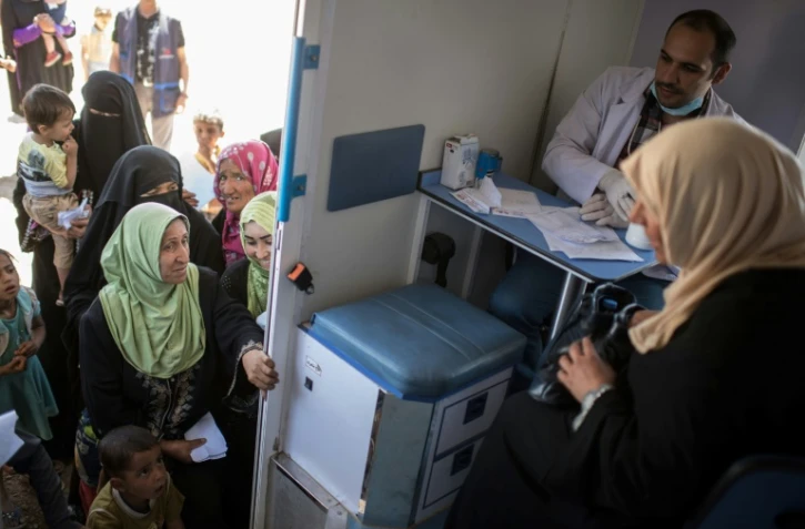 Des femmes et enfants irakiens font la queue devant une clinique mobile à Mossoul-Ouest, le 25 avril 2017