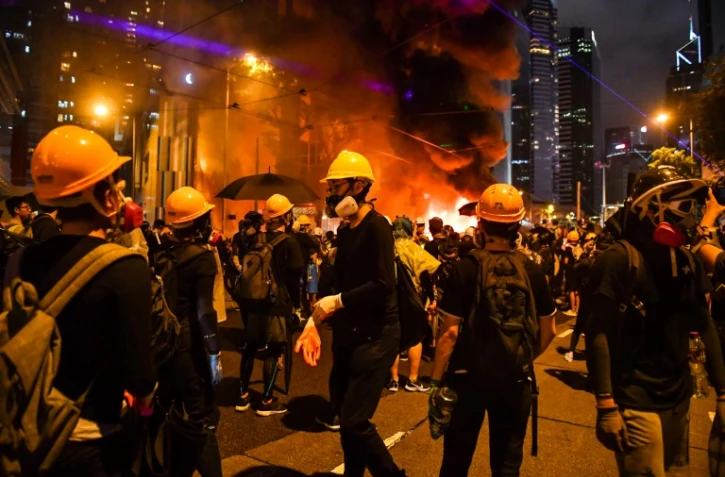 Des manifestants masqués occupent une barricade sur une grande artère de Hong Kong