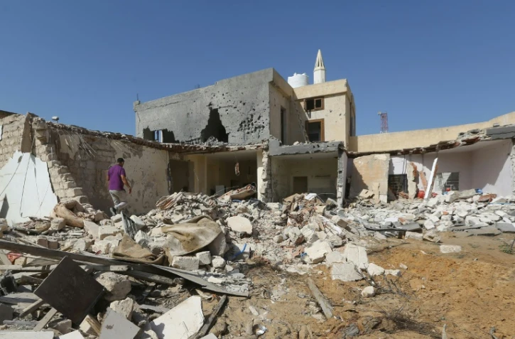 Des Libyens inspectent des ruines après un raid aérien dans lequel trois enfants ont été tués au sud de Tripoli le 14 octobre 2019.