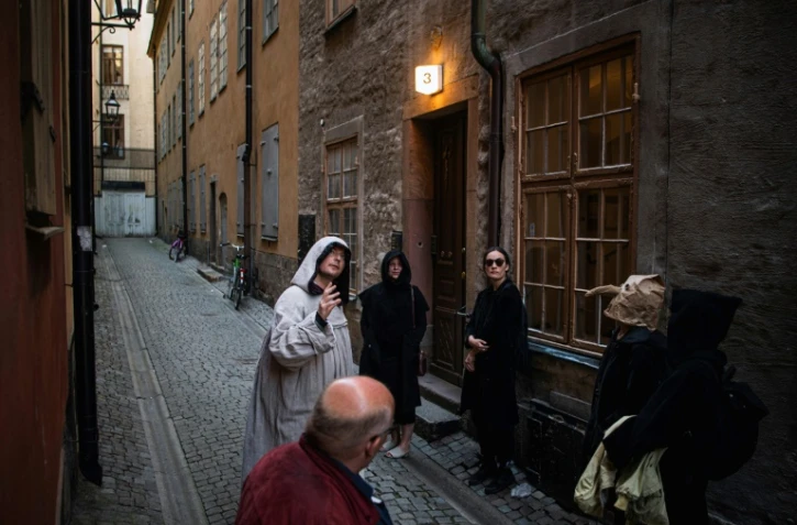Le guide Mike Anderson, en costume, promène les visiteurs dans une "marche contre la peste", le 30 mai 2020 à Stockholm, racontant les grandes épidémies du passé