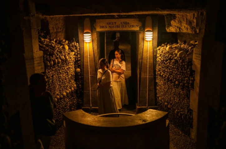 Des touristes visitent les Catacombes de Paris, le 12 août 2025