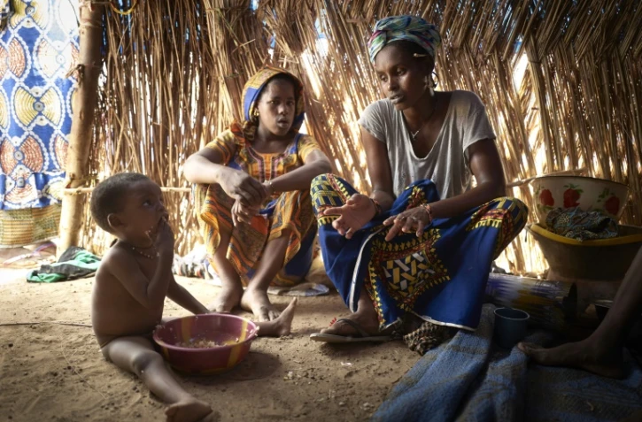 Une mère et ses enfants, de la communauté peule, sous une tente d'un camp de réfugiés installé dans la banlieue de Bamako, le 8 mai 2019