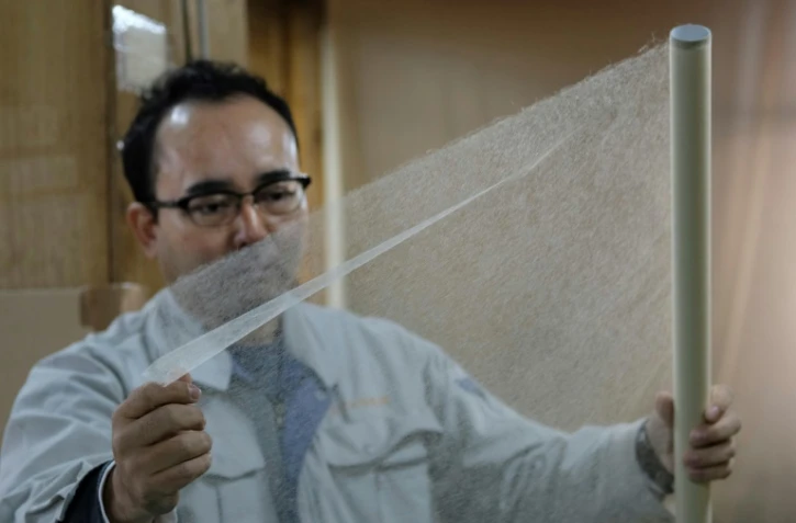 Hiroyoshi Chinzei vérifie la qualité du "washi", papier japonais, fabriqué dans son usine selon un processus qu'il a inventé pour restaurer des oeuvres d'art, le 15 mars 2019 à Hidaka, au Japon