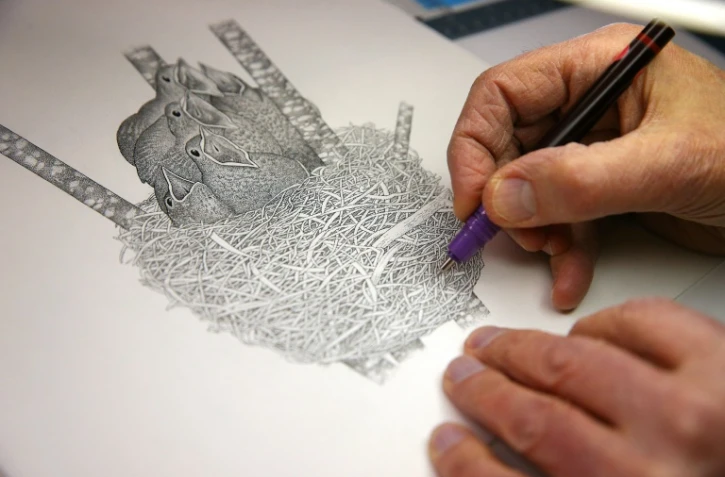 Le créateur du journal "La Hulotte" Pierre Déom réalise un dessin à l'encre de Chine, le 2 mars 2022 à Boult-aux-Bois dans les Ardennes