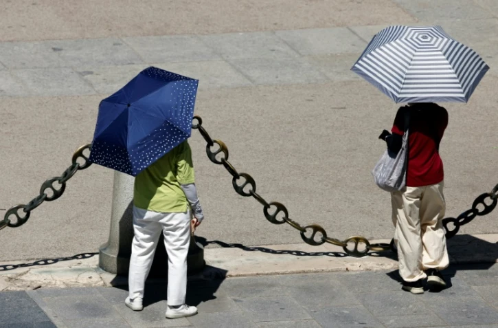Des gens s'abritent du soleil le 23 juillet 2024 à Madrid, en pleine vague de chaleur