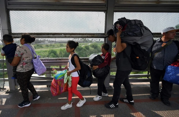 Des migrants traversent le pont de Matamoros-Brownsville après avoir obtenu un rendez-vous auprès des services de l'immigration américains afin d'entrer légalement sur le territoire des Etats-Unis, le 12 mai 2023 à Matamoros (Nord du Mexique)