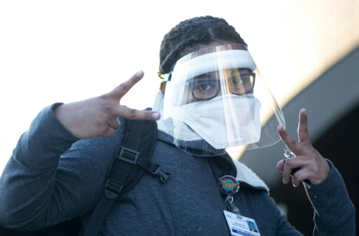 Un personnel soignant fait le signe de la victoire à son entrée au Elmhurst Hospital le 22 avril 2020 situé dans le quartier de Queens à New York.