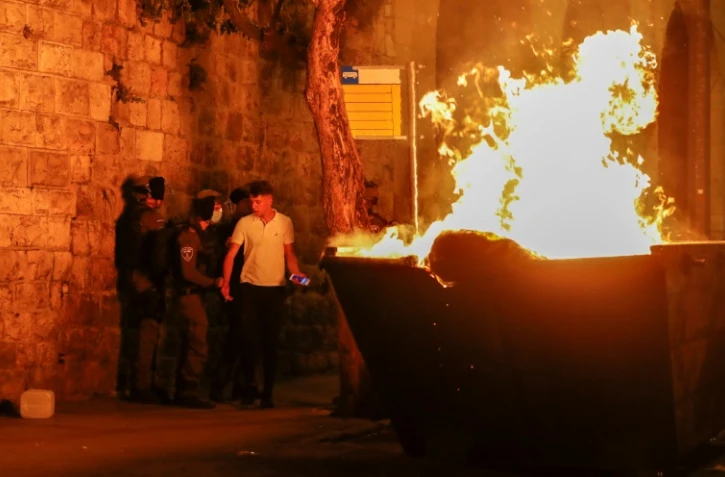 Une benne à gravats incendiée pendant des heurts près de la Porte de Damas à Jérusalem, dans la nuit du 23 au 24 avril 2021