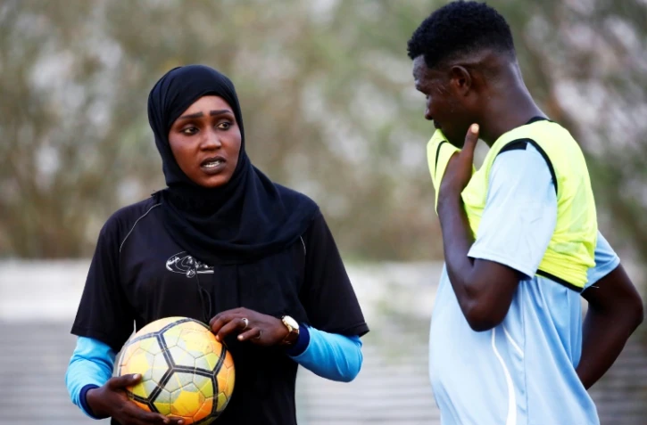 La Soudanaise Salma al-Majidi, première coach d'un club de foot, parle avec un joueur du club régional Al-Ahly, le 17 février 2018 à Al-Gadaref, à l'est de Khartoum