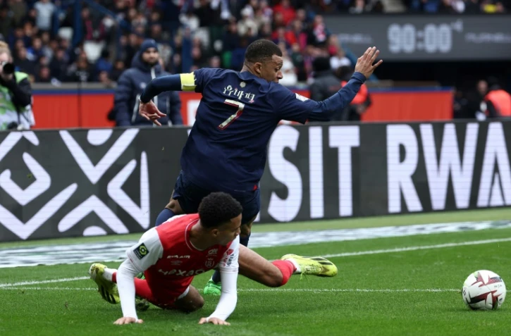 L'attaquant du PSG Kylian Mbappé taclé par le Rémois Amir Richardson, au Parc des Princes, le 10 mars 2024