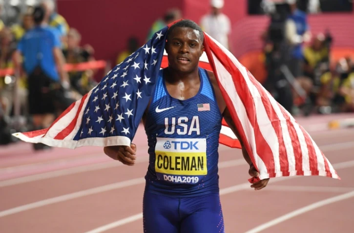 Le sprinteur américain Christian Coleman s'enroule dans le drapeau national après avoir gagné la finale du 100 m aux Mondiaux d'athlétisme, le 28 septembre 2019 à Doha