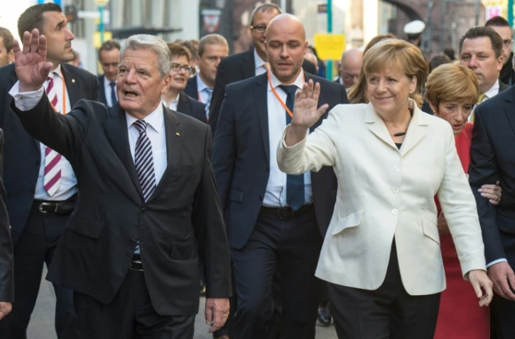 La Chancelière allemande Angela Merkel et le président Joachim Gauck saluent la foule, le 3 octobre 2015 à Francfort, à l'occasion des 25 ans de la Réunification de l'Allemagne