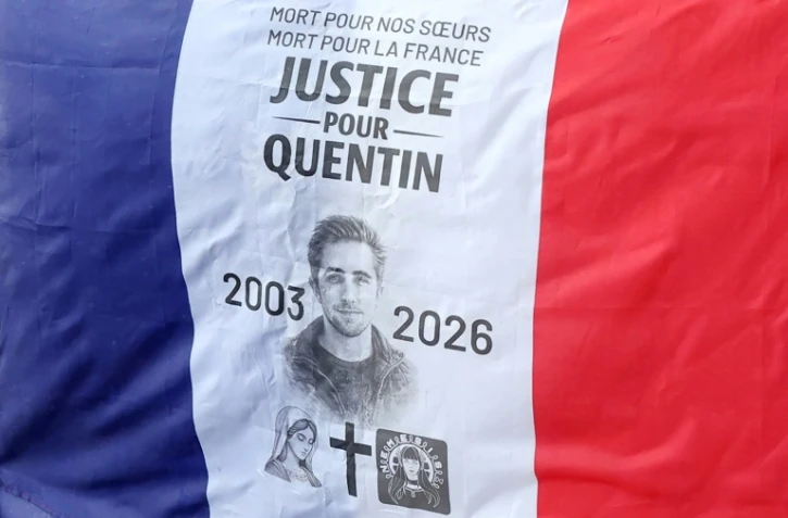 Un portrait de Quentin Deranque, décédée après une violente agression à Lyon, sur un drapeau français lors d'un rassemblement en son hommage à Paris, le 15 février 2026