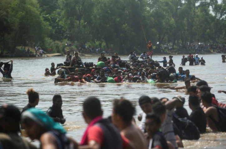 Des migrants honduriens, empêchés de passer par un pont, traversent la rivière Suchiate entre le Guatemala et le Mexique, dans l'espoir de rejoindre ensuite les Etats-Unis, le 29 octobre 2018.