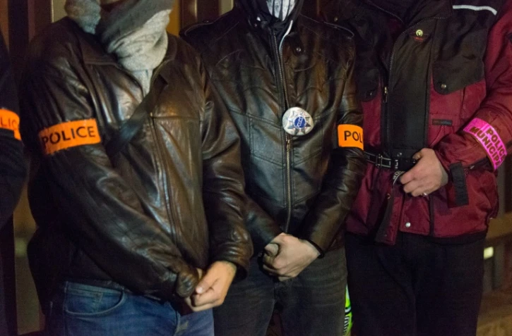 Des policiers participent à un mouvement de protestation silencieuse dans la nuit du 18 au 19 octobre 2016 devant l'hôpital Saint-Louis à Paris où est soigné un policier grièvement blessé par une quinzaine d'individus à Viry-Châtillon (Essonne)