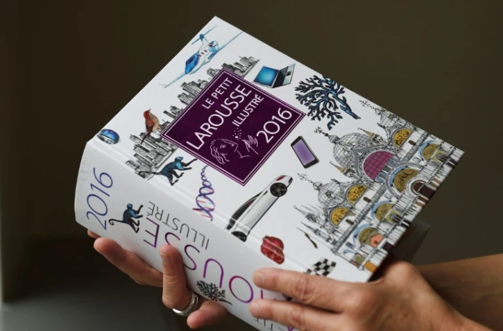 Une femme tient dans sa main un exemplaire du Petit Larousse illustré 2016, le 18 mai 2015 à Paris