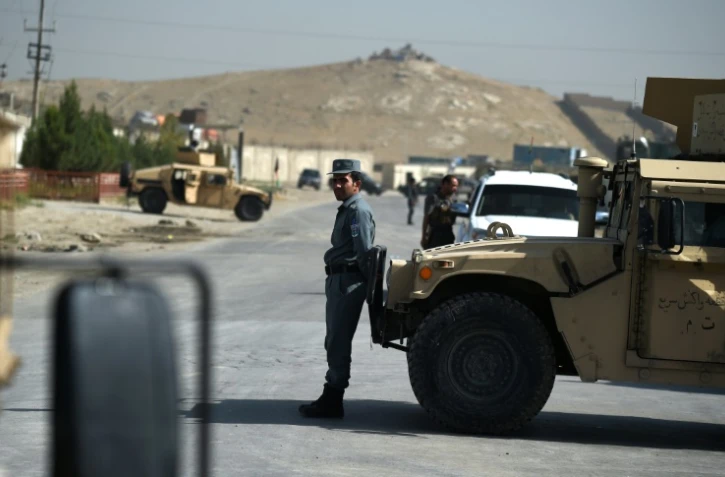 Un agent de sécurité afghan bloque une route dans les environs de Kaboul après une attaque contre un hôtel, le 1er août 2016