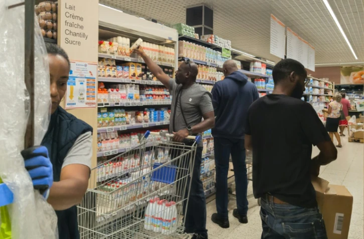Des clients cherchent des produits dans un supermarché près de Fort-de-France, en Martinique, le 23 septembre 2024