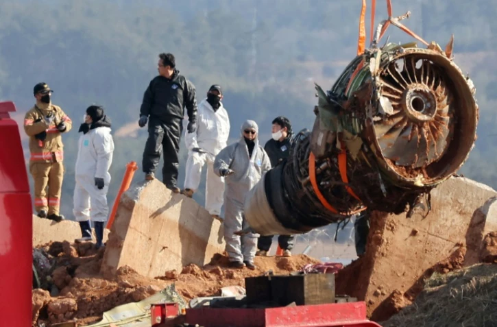 Des ouvriers retirent un réacteur du Boeing 737-800 de la Jeju air qui s'est écrasé sur l'aéroport de Muan en Corée du Sud, le 3 janvier 2025
