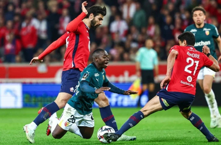 Le défenseur de Lens Nampalys Mendy (centre) chute après un duel avec les Lillois Angel Gomes (gauche) et Benjamin André (droite), lors de la 27e journée de L1, le 30 mars 2025 au stade Pierre-Mauroy 