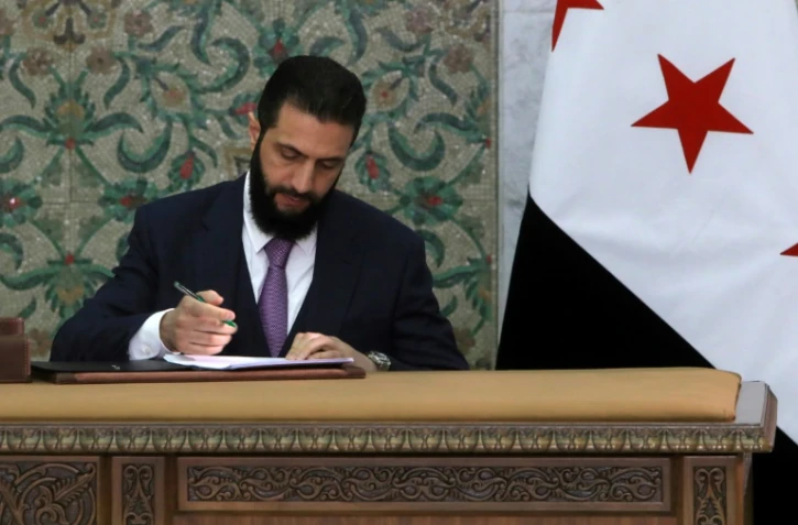 Le président par intérim de la Syrie, Ahmad al-Chareh, signe la déclaration constitutionnelle du pays, au palais présidentiel de Damas, le 13 mars 2025